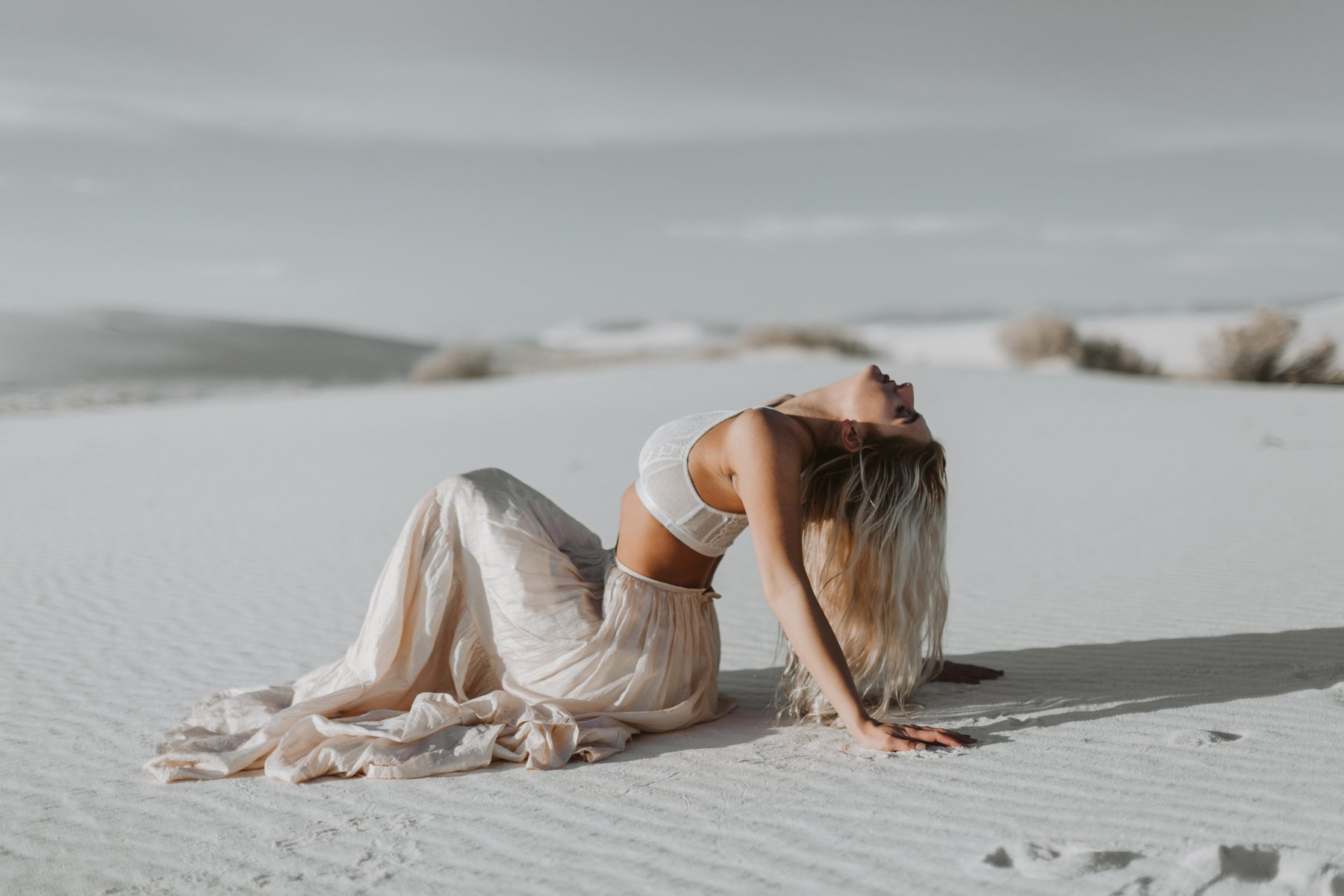 Woman Wearing White Bra Sitting on Desert